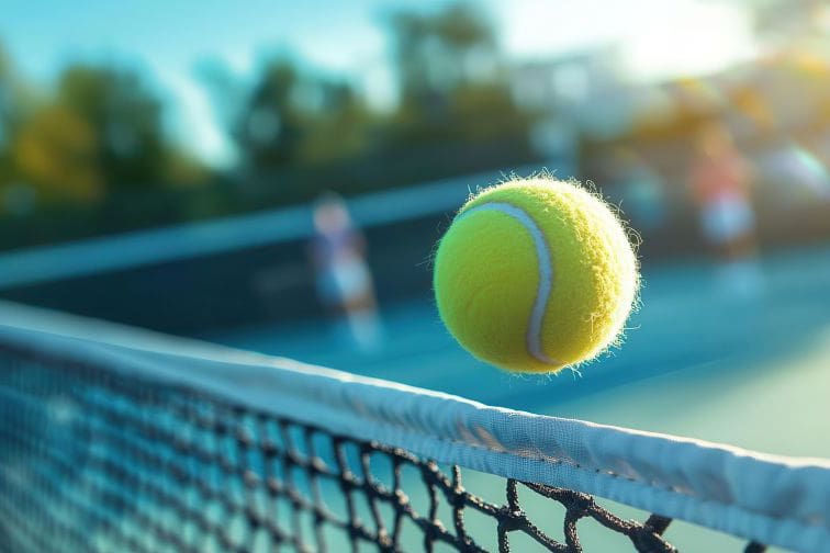 A tennis ball soaring over the net during a fastpaced rally, the court surface vibrant under the afternoon sun, players blurred in the background, ultrarealistic and energetic scene
